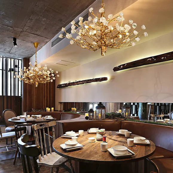 Modern restaurant interior with round wooden tables, chairs, and decorative lighting fixtures.