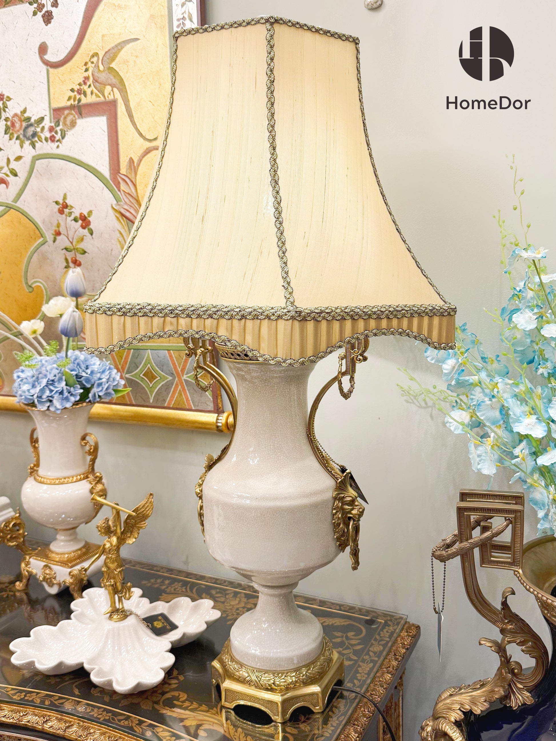 It pairs with a soft beige fabric shade, trimmed with intricate braided edging and tassel details