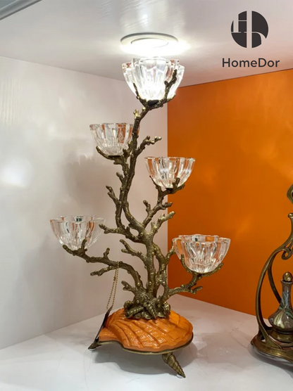 Candelabro de cristal con forma de rama de latón junto al mar de la colección Praga de HomeDor