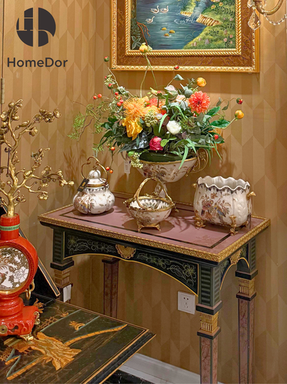 Consola sofisticada con incrustaciones de porcelana dorada en negro y rosa de HomeDor