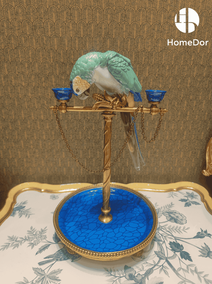 A sculptural parrot perches gracefully above a jewel-toned tray, creating a striking decorative accent that serves as both a candle holder and a catchall for jewelry, keys, trinkets, or treasured keepsakes. Rich turquoise hues, gilded detailing, and elegant chain accents bring a sense of tropical sophistication and collected luxury to the piece.