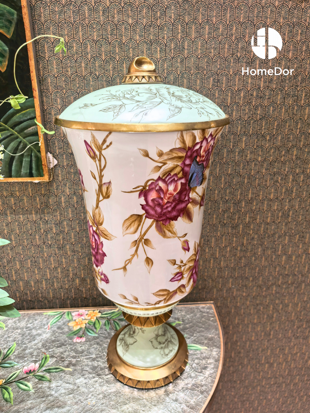 Porcelain lidded jar with pink roses, blue butterflies, and gold fluted base
