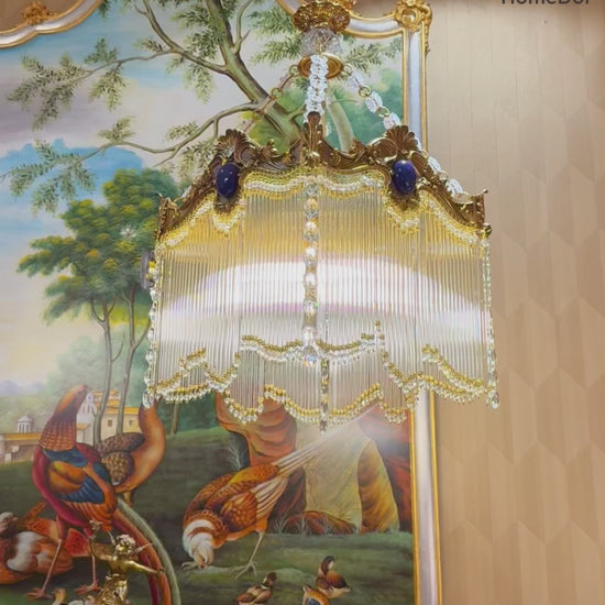  Designed in a retro-inspired aesthetic, its ornate structure pairs with dangling crystal tassels that catch light to cast a soft, luminous glow, making it a standout focal piece for any space.