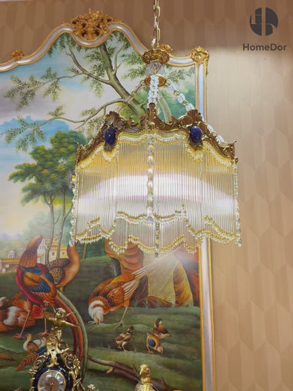  Designed in a retro-inspired aesthetic, its ornate structure pairs with dangling crystal tassels that catch light to cast a soft, luminous glow, making it a standout focal piece for any space.