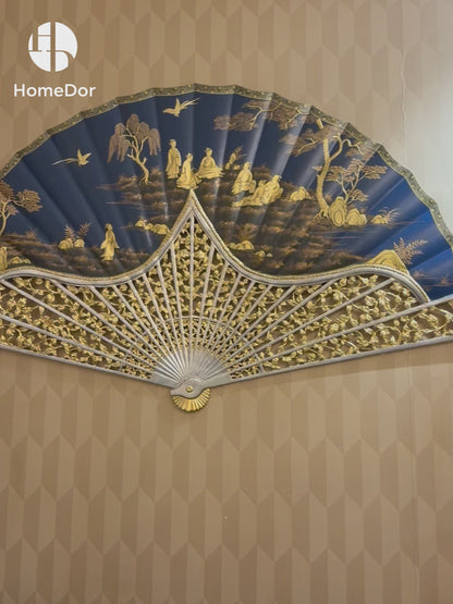 Grand Royal Blue Chinese Figure Scenery Gold Painted Fan Wall Art that blends imperial elegance with traditional Chinese artistry. Featuring intricate gold-painted figures amidst a serene landscape, set against a rich royal blue backdrop, this fan-shaped artwork is framed with ornate carved detailing, exuding a sense of regal sophistication